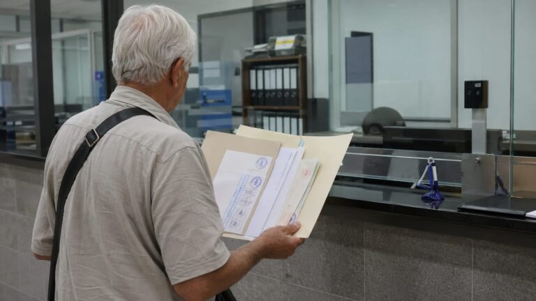 Пенсионная виза Таиланд: пожилой иностранец с банковскими документами у стойки тайского иммиграционного офиса.